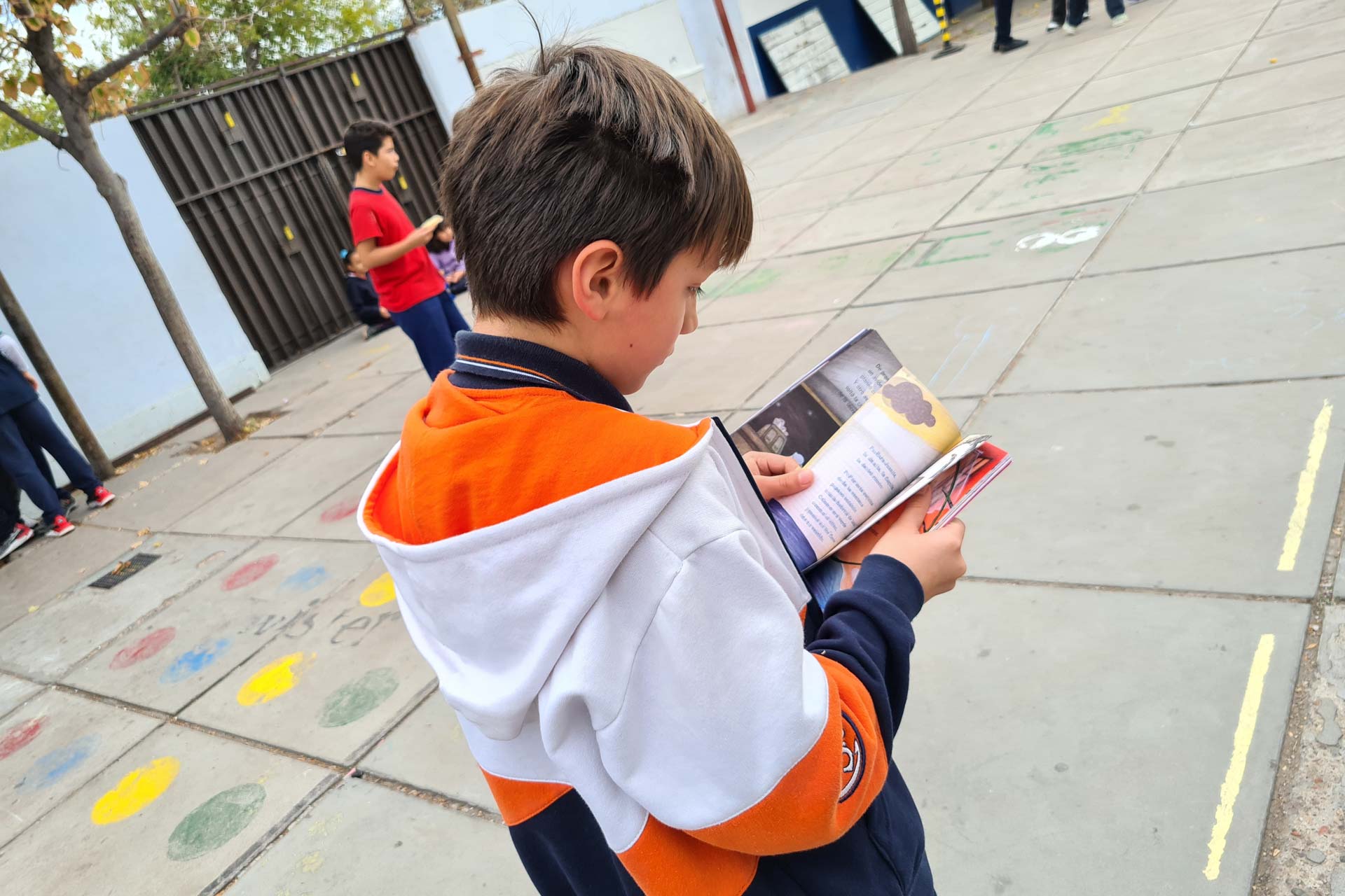 Niño leyendo en la vía pública