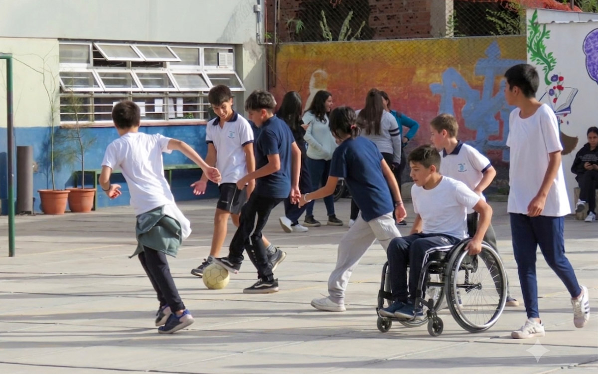 estudiantes en el patio escolar- pelota-silla de ruedas