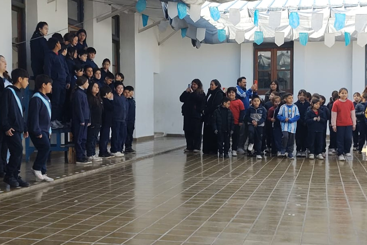 Estudiantes-en-acto-escolar-banda-militar-abanderado-y-escoltas-soldados-patio-de-escuela.