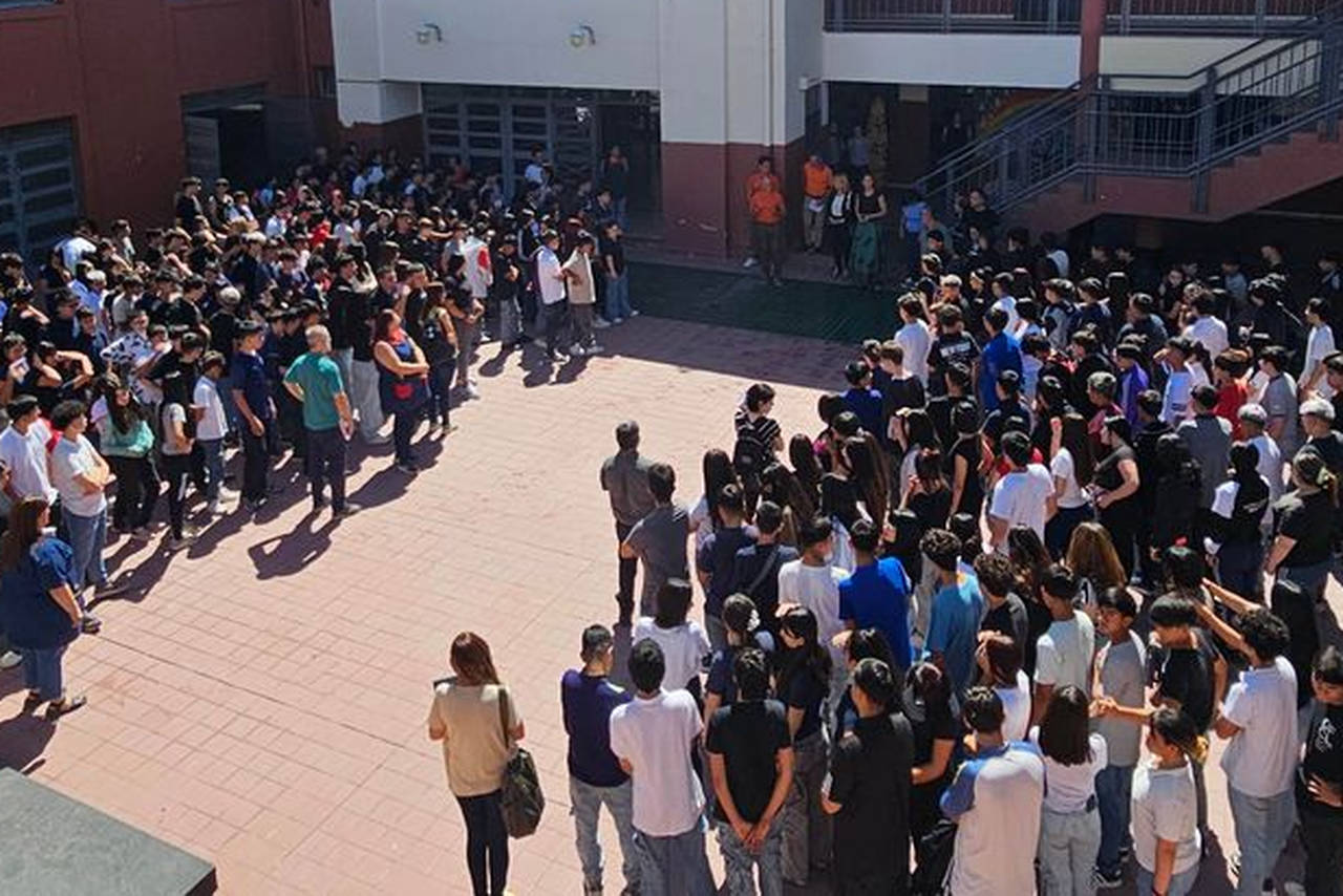 estudiantes en patio escolar haciendo simulacro de sismo