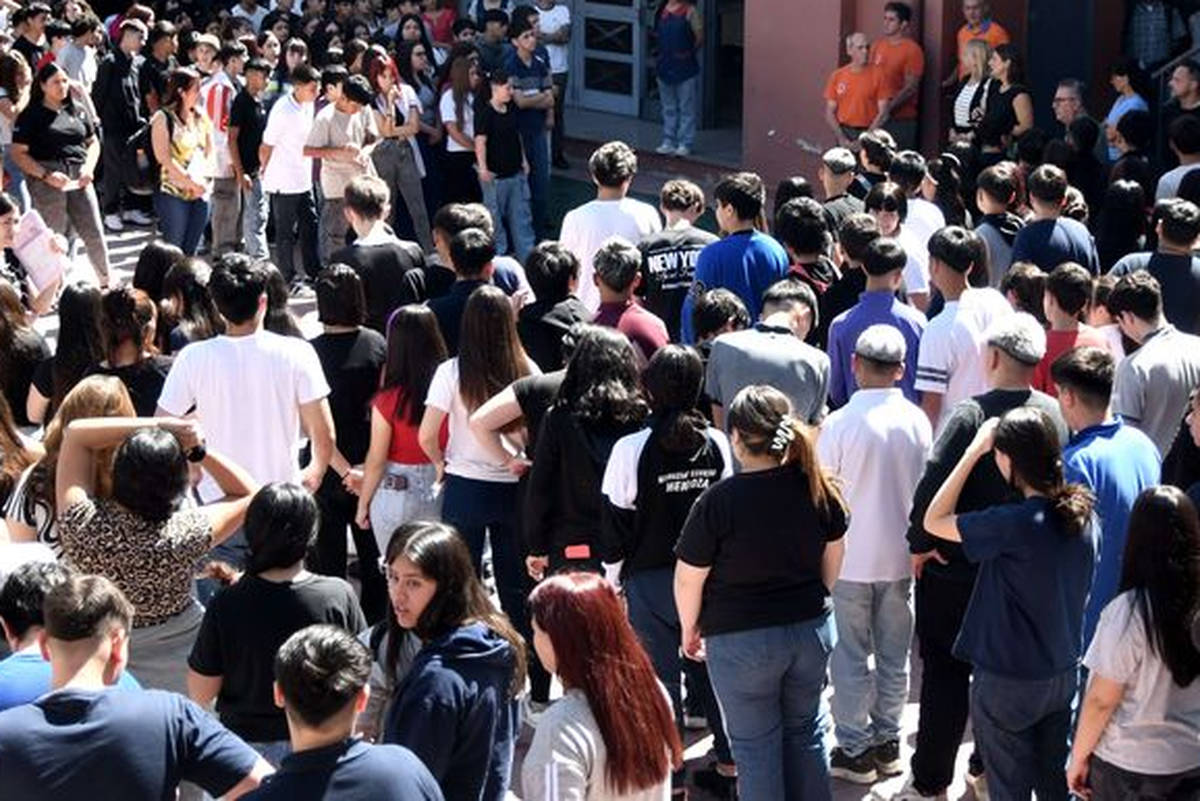 estudiantes en patio escolar haciendo simulacro de sismo